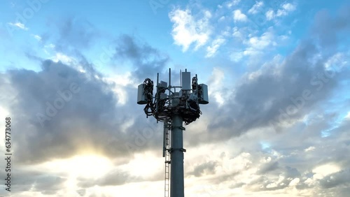 Drone video of modern communications tower antenna array at top for internet and mobile phone communications at sunset