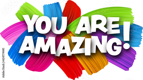 You are amazing paper word sign with colorful spectrum paint brush strokes over white.