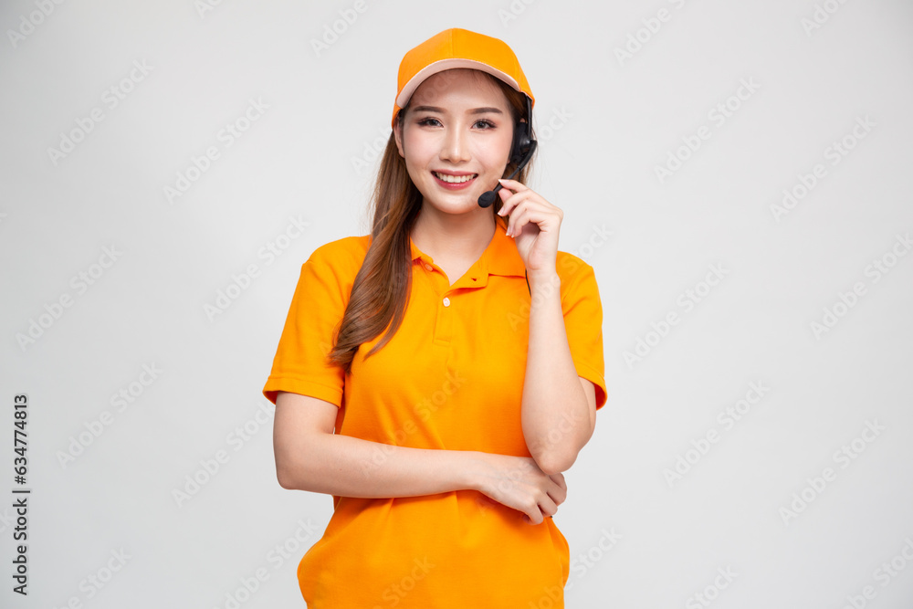 Young Asian woman call center in delivery orange uniform outfit with headsets isolated over white background, Telemarketing sales or Customer service operators concept Young Asian woman call center in delivery orange uniform outfit with headsets isolated over white background, Telemarketing sales or Customer service operators concept