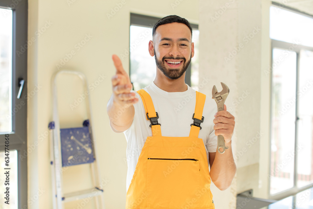 arab handsome man arab man smiling happily and offering or showing a concept. handyman with a wrench arab handsome man arab man smiling happily and offering or showing a concept. handyman with a wrench