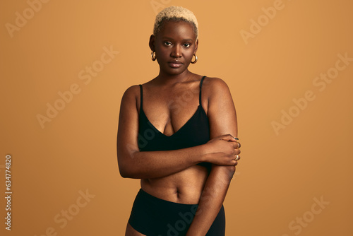 Confident black woman in underwear in studio
