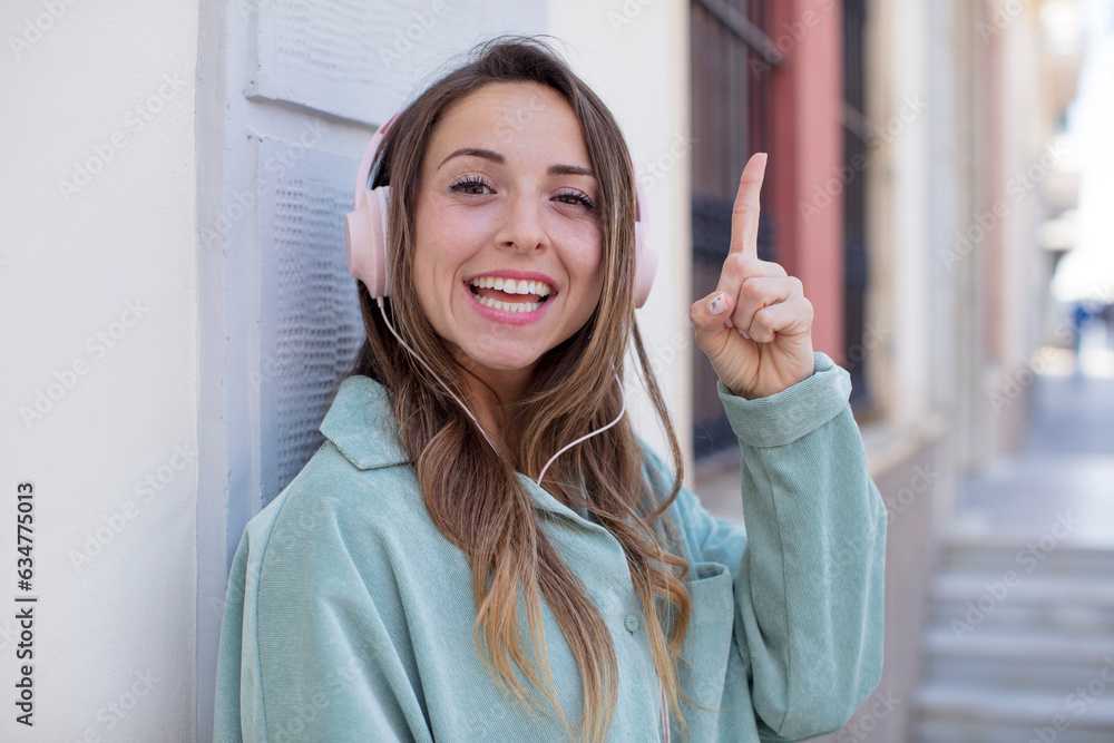 pretty woman feeling like a happy and excited genius after realizing an idea. headphones and music concept pretty woman feeling like a happy and excited genius after realizing an idea. headphones and music concept