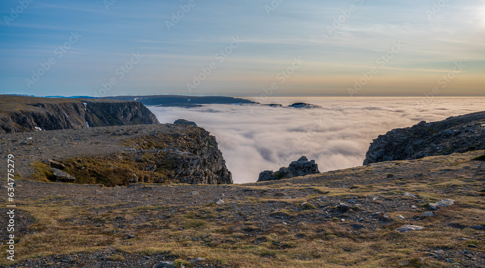 Obraz premium Rocky cliff and wonderful view of the clouds below
