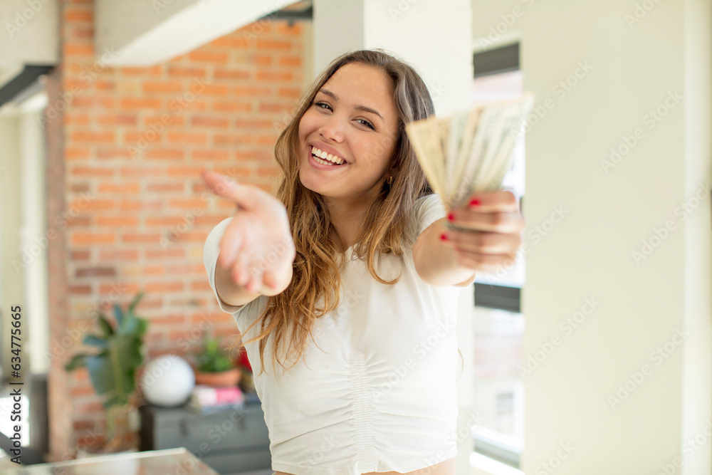 pretty woman smiling happily and offering or showing a concept. dollar banknotes concept