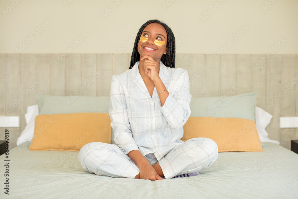 black afro woman smiling with a happy, confident expression with hand on chin. rest and nightwear concept black afro woman smiling with a happy, confident expression with hand on chin. rest and nightwear concept