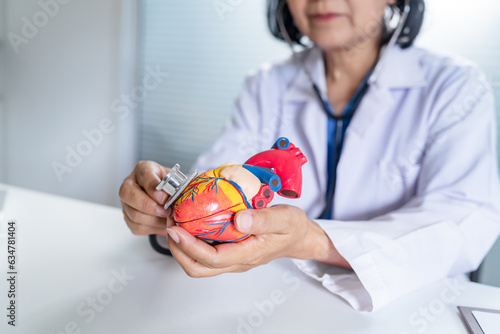 Cardiologist supports the heart senior asian woman doctor wearing glasses and uniform. portrait of mature old asian woman medic professional