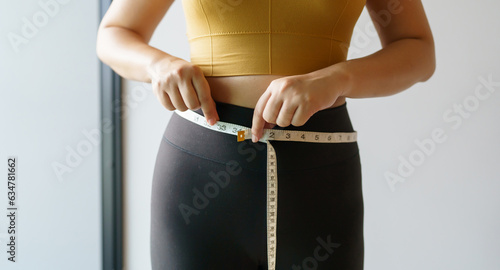 Tablou pe pânză woman want to lose weight with a centimeter Shape up healthy stomach muscle and