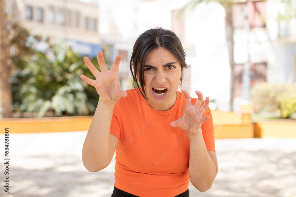 pretty woman screaming in panic or anger, shocked, terrified or furious, with hands next to head pretty woman screaming in panic or anger, shocked, terrified or furious, with hands next to head