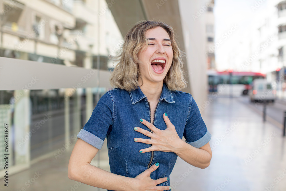 Fototapeta premium pretty woman laughing out loud at some hilarious joke, feeling happy and cheerful, having fun