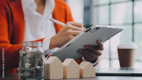 saving money and accounting concept. business man putting coin insert to jar and make acounting book for finance management to investment and saving. photo