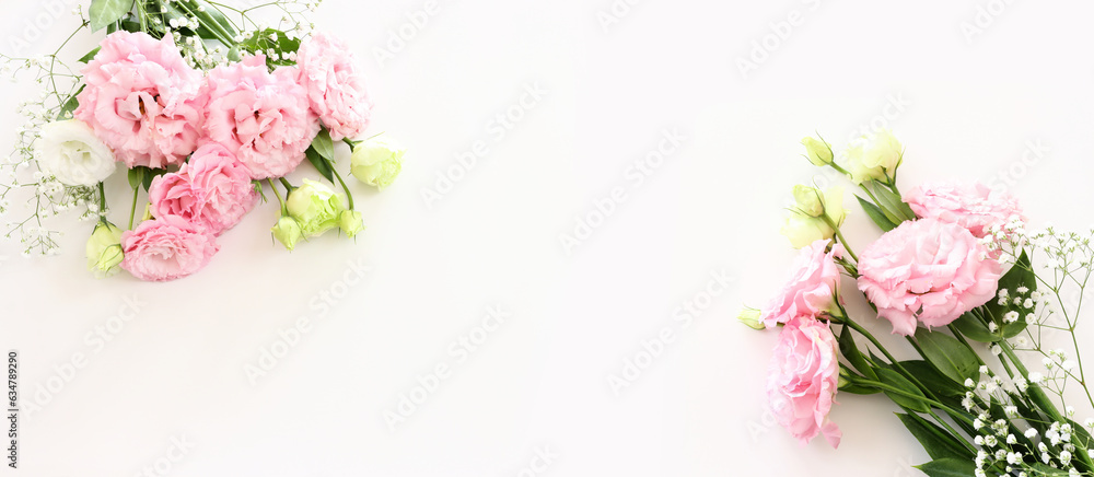 Top view image of delicate pink flowers over white background
