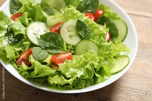 Delicious salad in bowl on wooden table, closeup