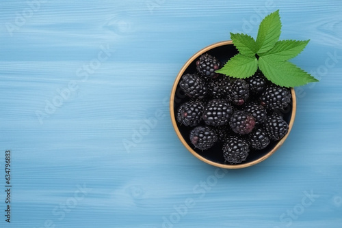 Blackberry with leaf in bowl on blue wooden background.Generative Ai.