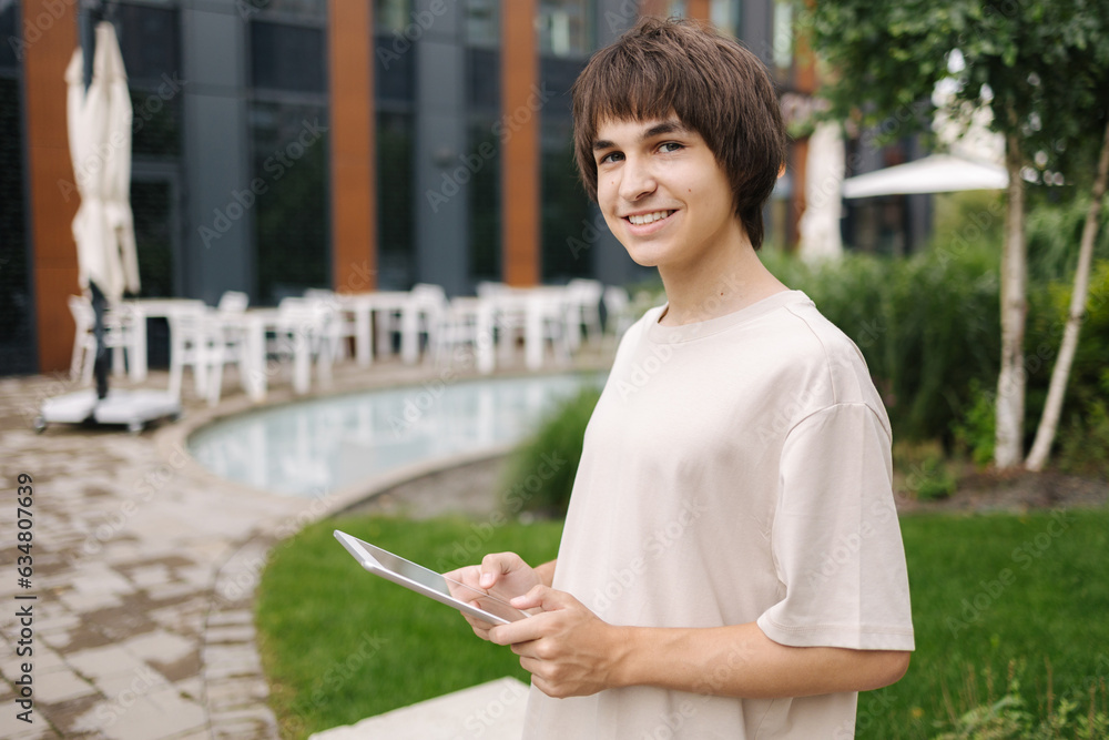 Portrait of young smart student using tablet near the college Portrait of young smart student using tablet near the college