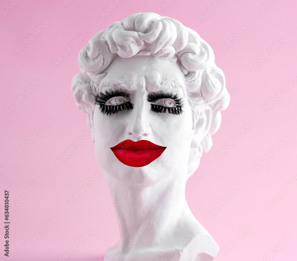 Plaster statue head wearing eyelashes and big red lips pink background. Minimal art poster. Beauty procedure concept. Plaster statue head wearing eyelashes and big red lips pink background. Minimal art poster. Beauty procedure concept.