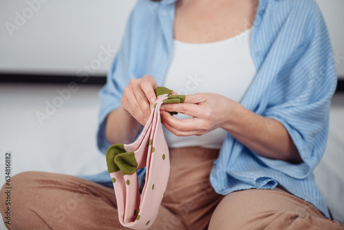 woman puts green socks on her feet. Isolated on white background