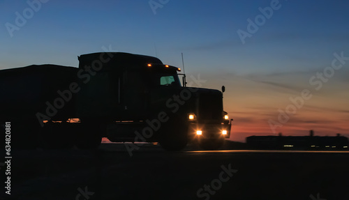Truck drives along a suburban highway in the evening at sunset