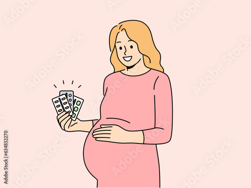 Pregnant woman holds blisters of pills and vitamins to support immunity of baby in womb. Pregnant expectant mother recommends taking useful medicines to get rid of health problems.