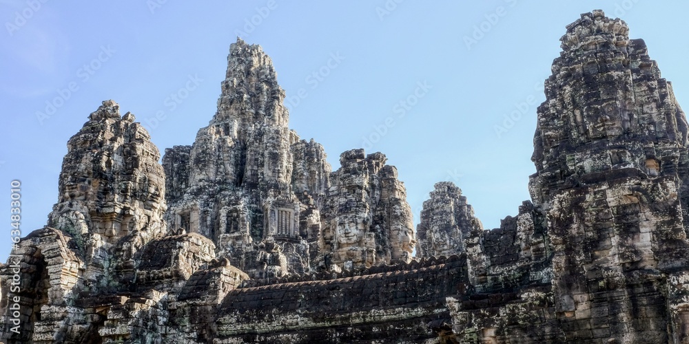 General view of the ancient Bayon Temple in Cambodia on a sunny day, stone towers with human faces. General view of the ancient Bayon Temple in Cambodia on a sunny day, stone towers with human faces.