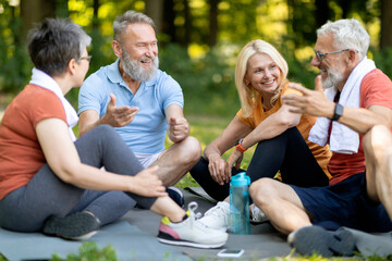 Group of sporty senior people resting together after outdoor fitness workout