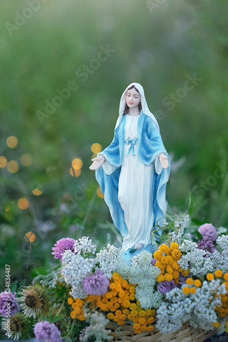 Foto Our Lady figurine and sacred herbs on abstract natural background