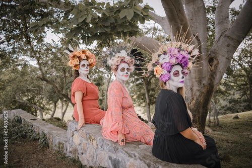 Women made up as catrinas. Day of the dead and Halloween makeup. Outdoor group portrait of three women © sandor