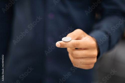 Foto Man's hand throwing up coin to make a decision