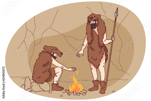 Cavemen in animal fur clothes setting fire outside. Tribal men making bonfire during ancient ages outdoors. Flat vector illustration.