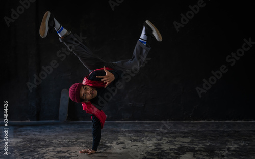 Confidence young male hip hop showing breakdance on the stage in the studio.