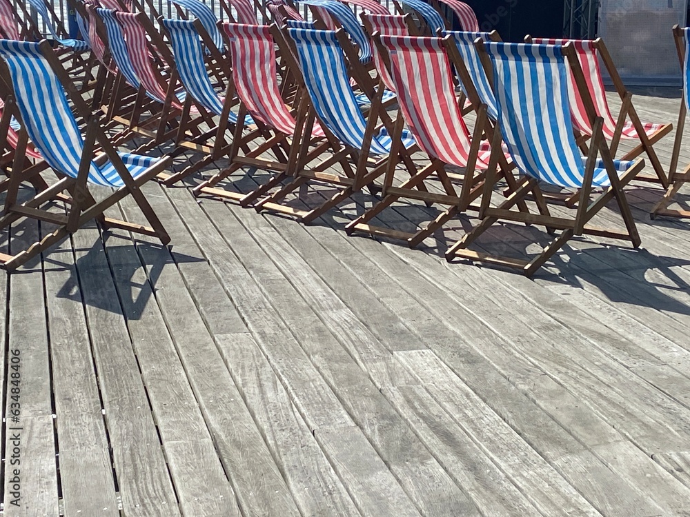 deck chairs on pier wooden striped empty on windy day deck chairs on pier wooden striped empty on windy day