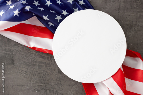 Getting involved in the national Labor Day enthusiasm. Top view composition of american national flag on concrete grey background with blank circle for promo or message