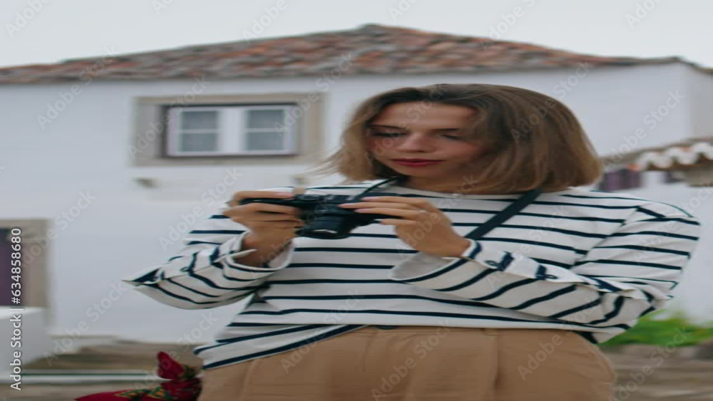 Girl making travel pictures walking old town. Vertical tourist exploring city Girl making travel pictures walking old town. Vertical tourist exploring city