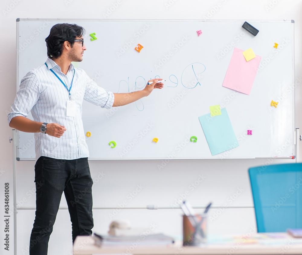 Fototapeta premium Young handsome male designer working in the office