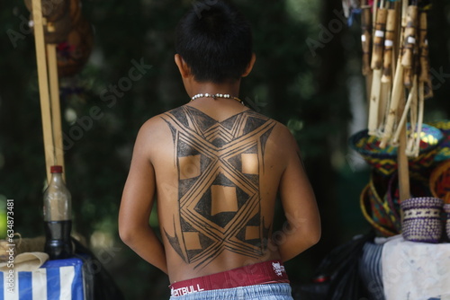 Brazilian indigenous boy with body painted back tatoo with ink. International Day of Indigenous Peoples celebration