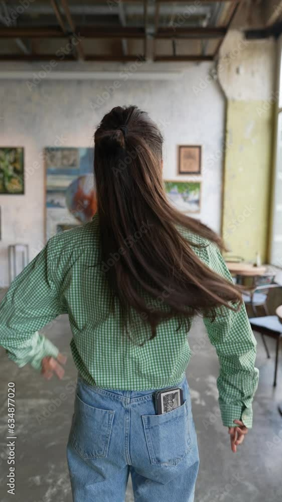 Beautiful girl is examining paintings at the exhibition. Beautiful girl is examining paintings at the exhibition.