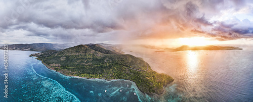 фотографія Stretching across the horizon, a panoramic view captures nature's diverse canvas: placid waters in the foreground, stoic mountains standing tall beyond, all under the fiery embrace of a setting sun