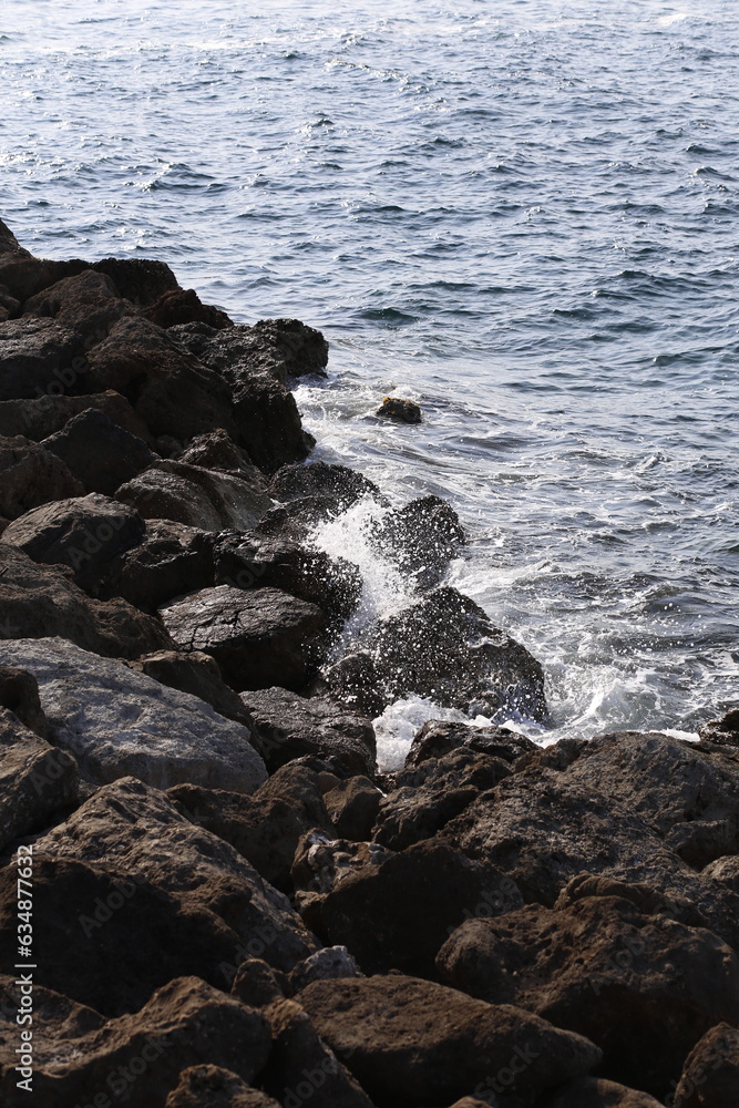 Mediterranean water sea crashing to the rocks of a breakwater pier landscape