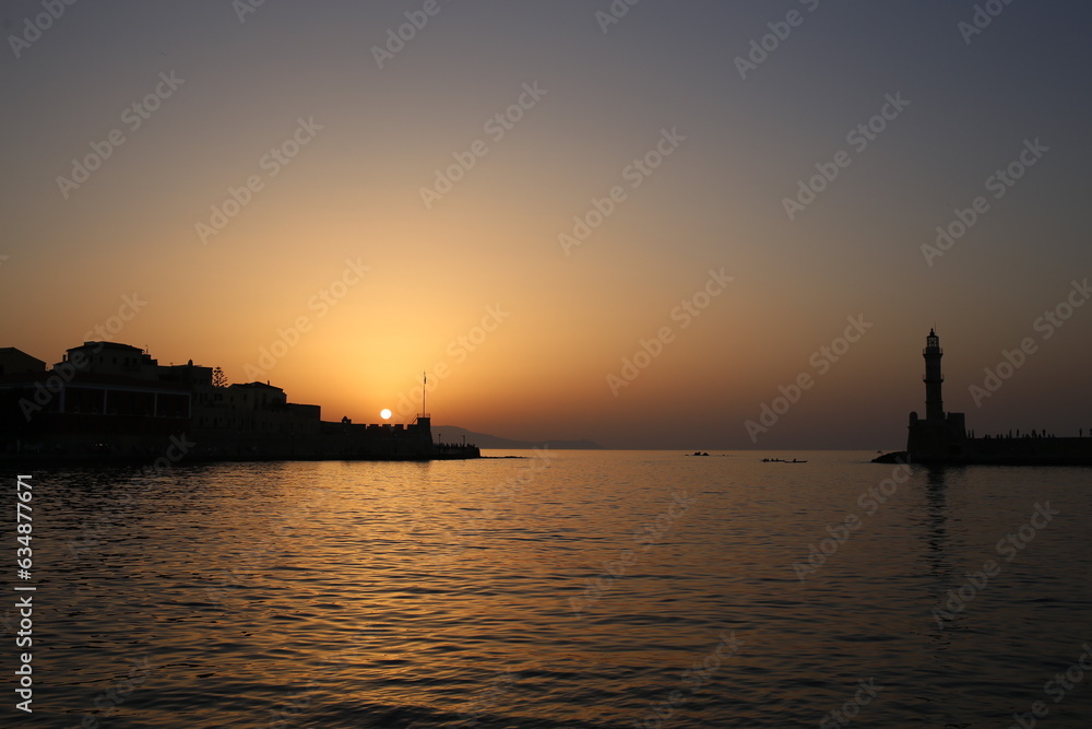 Chania lighthouse landmark silhouette in a beautiful coastal sunset landscape in the Mediterranean Sea in Crete, Greece