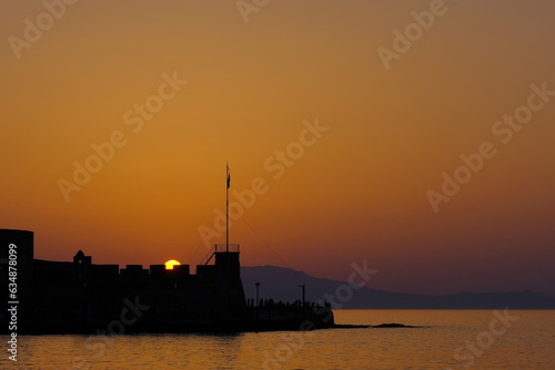 Orange sun setting down in a beautiful coastal landscape in Khania, Crete island in Greece