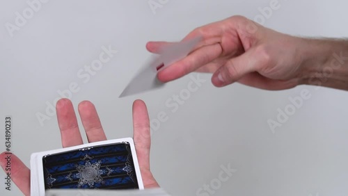 The croupier, the magician, shows a tricks with playing cards and shuffle it. Focus changing.