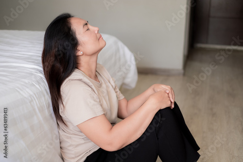 Sad depressed asia woman suffering on the white bed, she is sitting in bed and touching her forehead, sleep disorder and stress concept