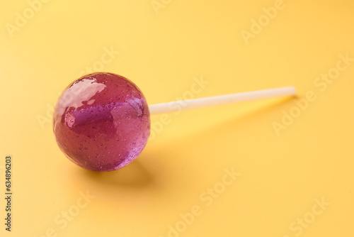 One tasty lollipop on yellow background, closeup