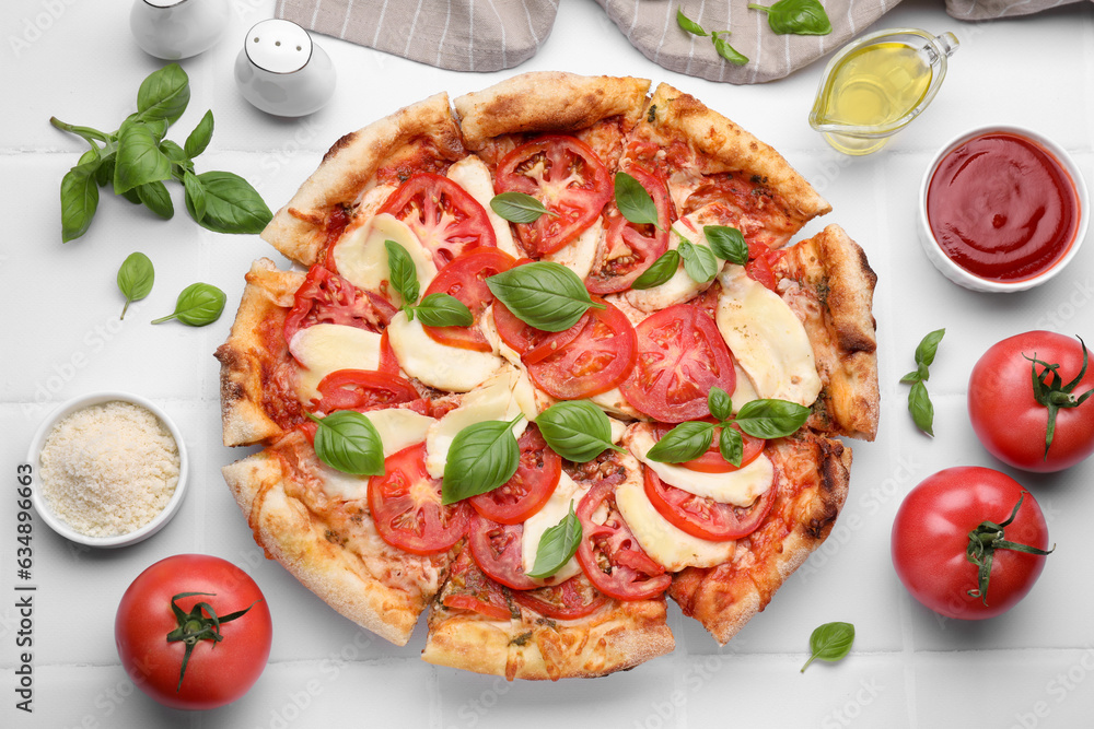 Delicious Caprese pizza and ingredients on white tiled table, flat lay