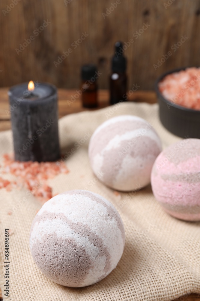 Bath bombs, sea salt, and burning candle on table, closeup Bath bombs, sea salt, and burning candle on table, closeup
