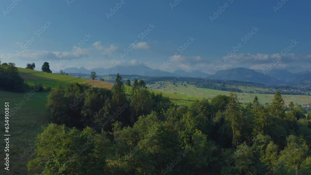 Rising On Green Sloping Mountains Revealing Countryside Township In Dzianisz, Tatra County, Southern Poland. Aerial Ascending Rising On Green Sloping Mountains Revealing Countryside Township In Dzianisz, Tatra County, Southern Poland. Aerial Ascending