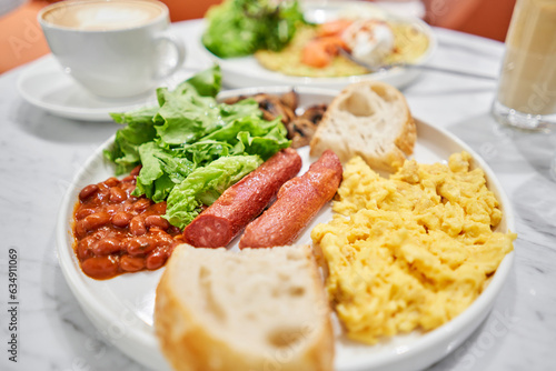 Simple American style Breakfast with sausages, scrambled eggs, baked beans, mushrooms and tomatoes. This dish is full of nutrients that you needed.