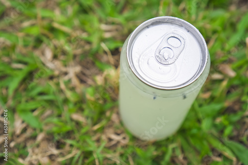 Cold drinks in plastic transparent cans with bokeh grass lawn background - Natural sunlight. Concept for Healthy food, summer thirsty, hot temperature, global boiling, dehidration. Minuman Kaleng. photo
