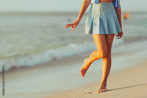 Teen girl's legs on the beach closeup. Girl walking on the beach
