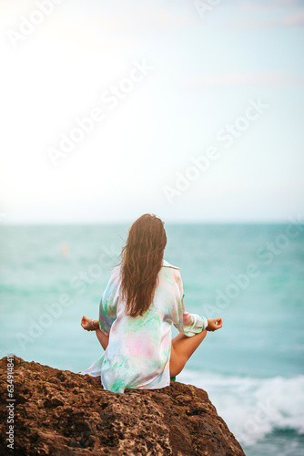 Young woman with practicing yoga on the beach