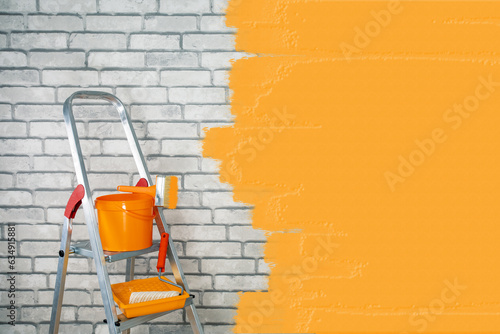  buckets with paint roller, brush and folding ladder for painting walls. renovation concept. place for text.